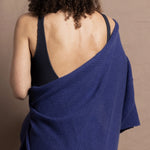 A woman wears a bright blue cashmere shawl wrapped around her