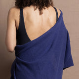 A woman wears a bright blue cashmere shawl wrapped around her