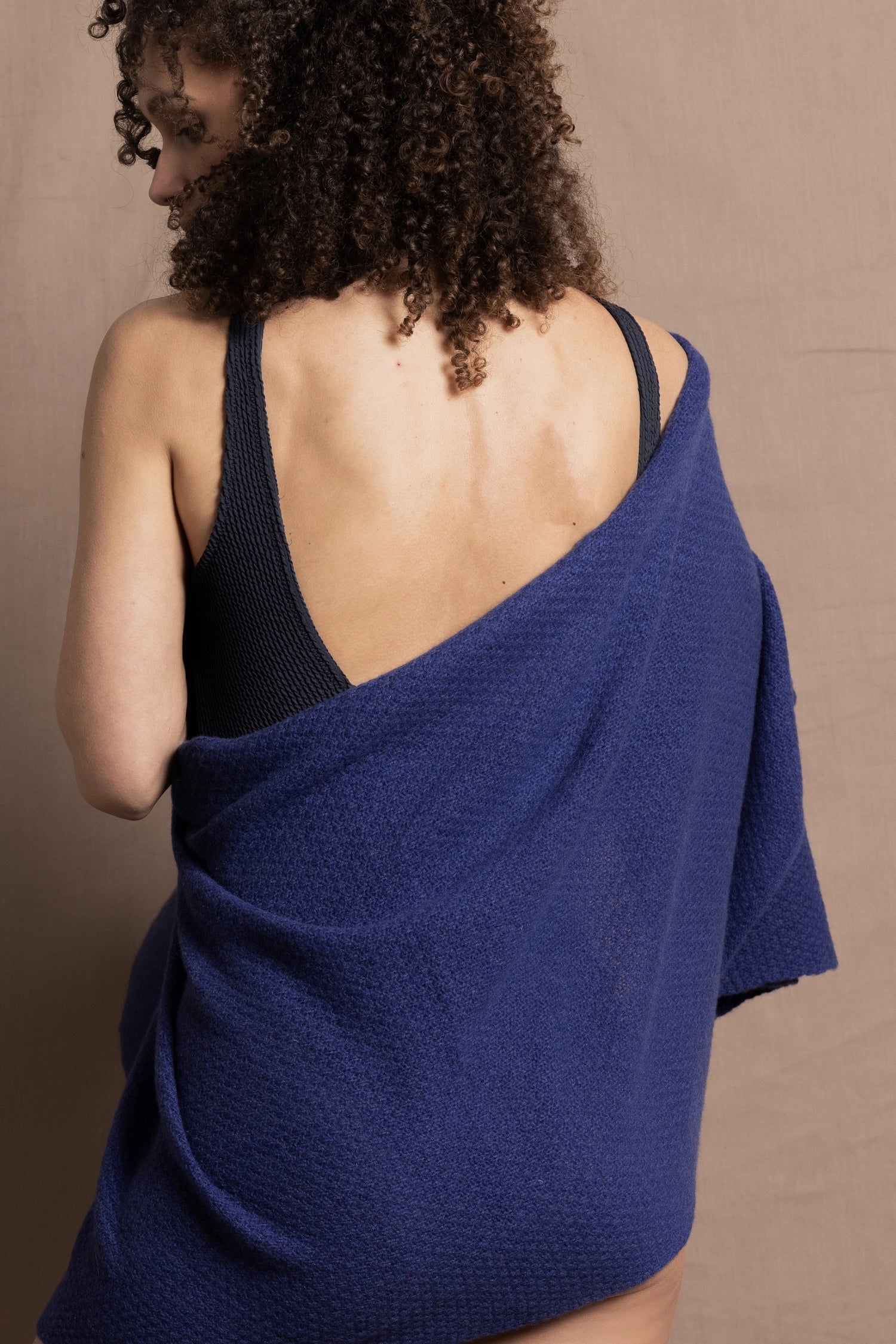 A woman wears a bright blue cashmere shawl wrapped around her