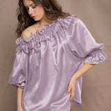 woman wears a pale purple silk blouse with ruffle detailing by Irish brand Madigan