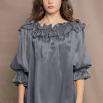 a woman wears a pewter grey silk top 
