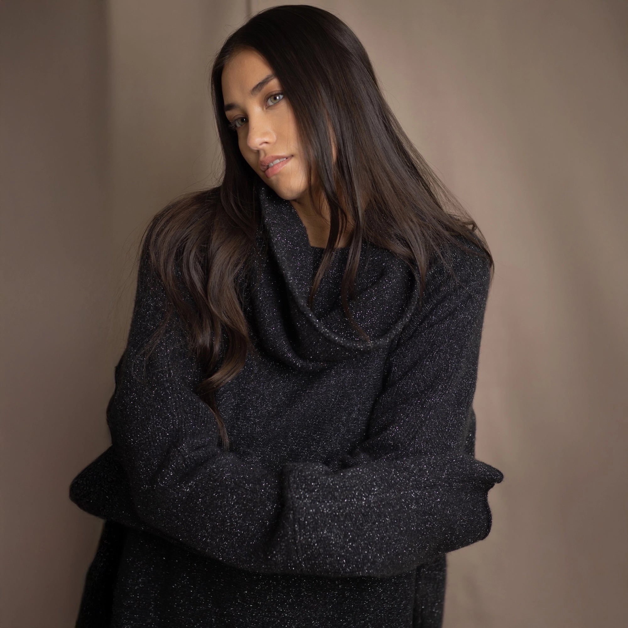 Woman wearing an oversized cashmere sweater in black with silver sparkles
