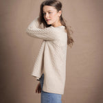 A lady wears a traditional Irish Cashmere Aran Cardigan Sweater in Beige