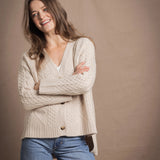 A lady wears a traditional Irish Cashmere Aran Cardigan Sweater in Beige