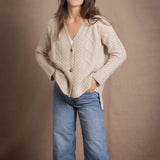 A lady wears a traditional Irish Cashmere Aran Cardigan Sweater in Beige