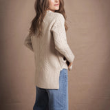A lady wears a traditional Irish Cashmere Aran Cardigan Sweater in Beige