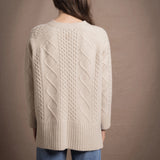 A lady wears a traditional Irish Cashmere Aran Cardigan Sweater in Beige
