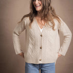 A lady wears a traditional Irish Cashmere Aran Cardigan Sweater in Beige