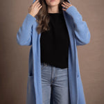lady standing with 100% cashmere tee short sleeve sweater in black with blue cashmere coat over top