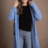 lady standing with 100% cashmere tee short sleeve sweater in black with blue cashmere coat over top