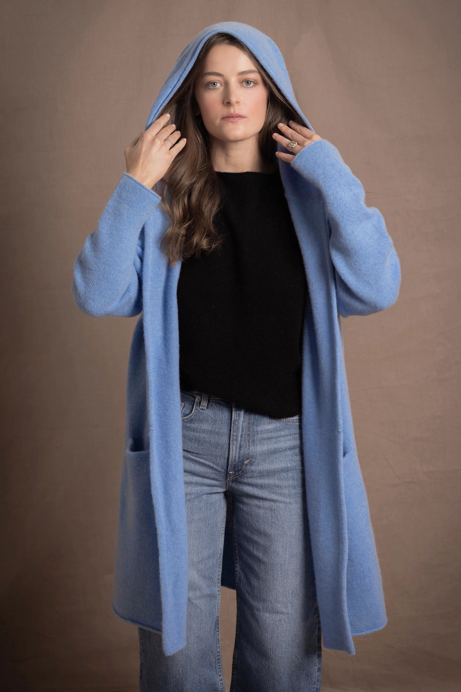 lady standing with 100% cashmere tee short sleeve sweater in black with blue cashmere coat over top