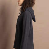 lady looks sideways wearing an oversized pure cashmere hoodie sweater in grey blue colour