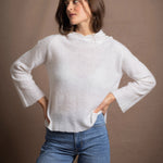 A lady wears a relaxed 100% pure cashmere jumper in a pointelle texture in white with jeans