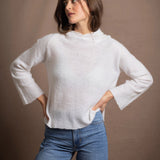 A lady wears a relaxed 100% pure cashmere jumper in a pointelle texture in white with jeans