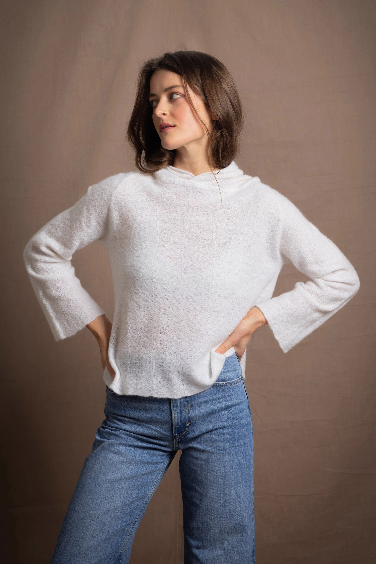 A lady wears a relaxed 100% pure cashmere jumper in a pointelle texture in white with jeans