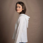 A lady wears a relaxed 100% pure cashmere jumper in a pointelle texture in white with jeans