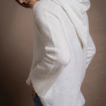 A lady wears a relaxed 100% pure cashmere sweater in a pointelle texture in white with jeans