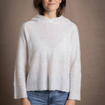 A lady wears a relaxed 100% pure cashmere sweater in a pointelle texture in white with jeans