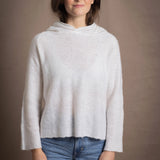 A lady wears a relaxed 100% pure cashmere sweater in a pointelle texture in white with jeans