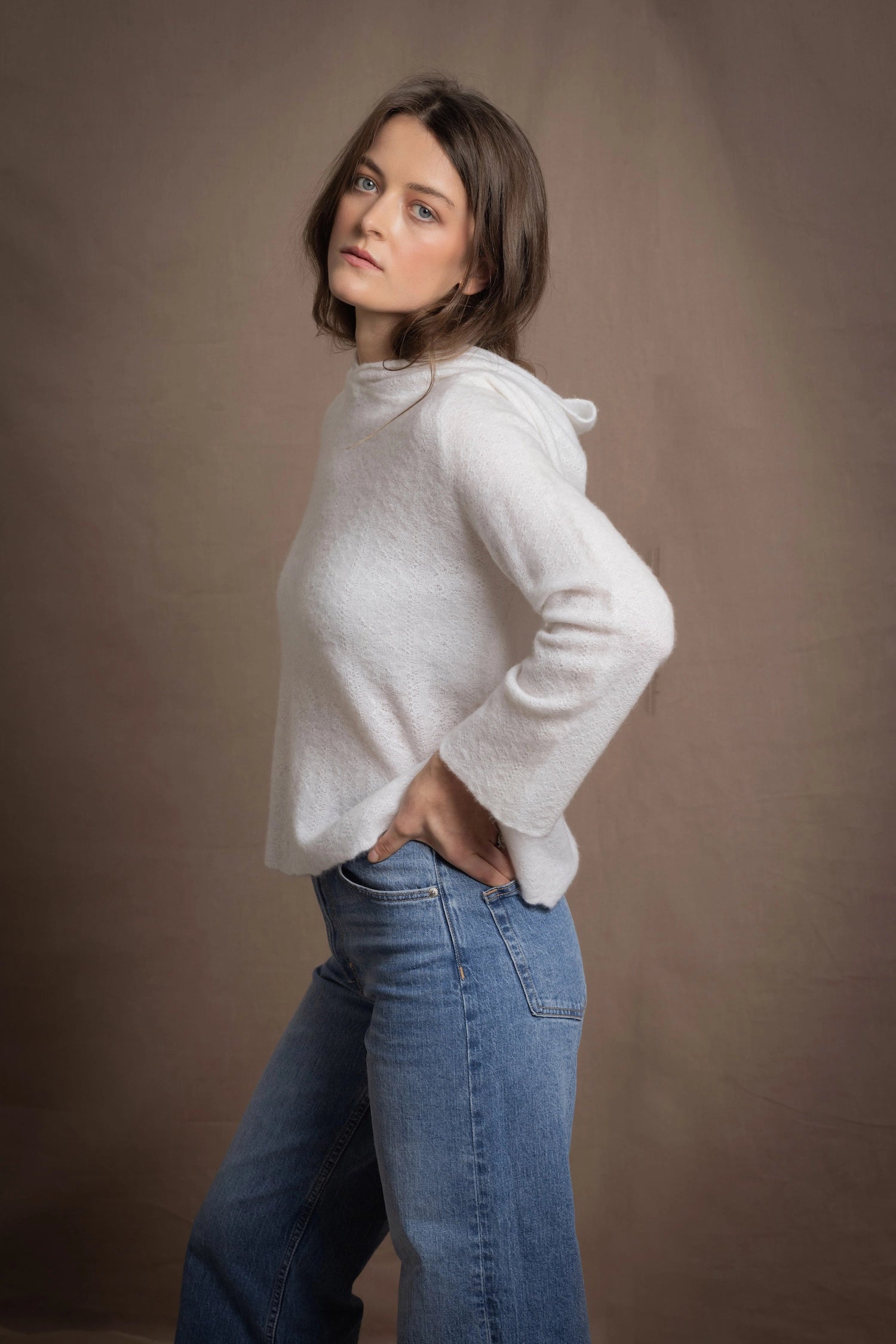 A lady wears a relaxed 100% pure cashmere sweater in a pointelle texture in white with jeans