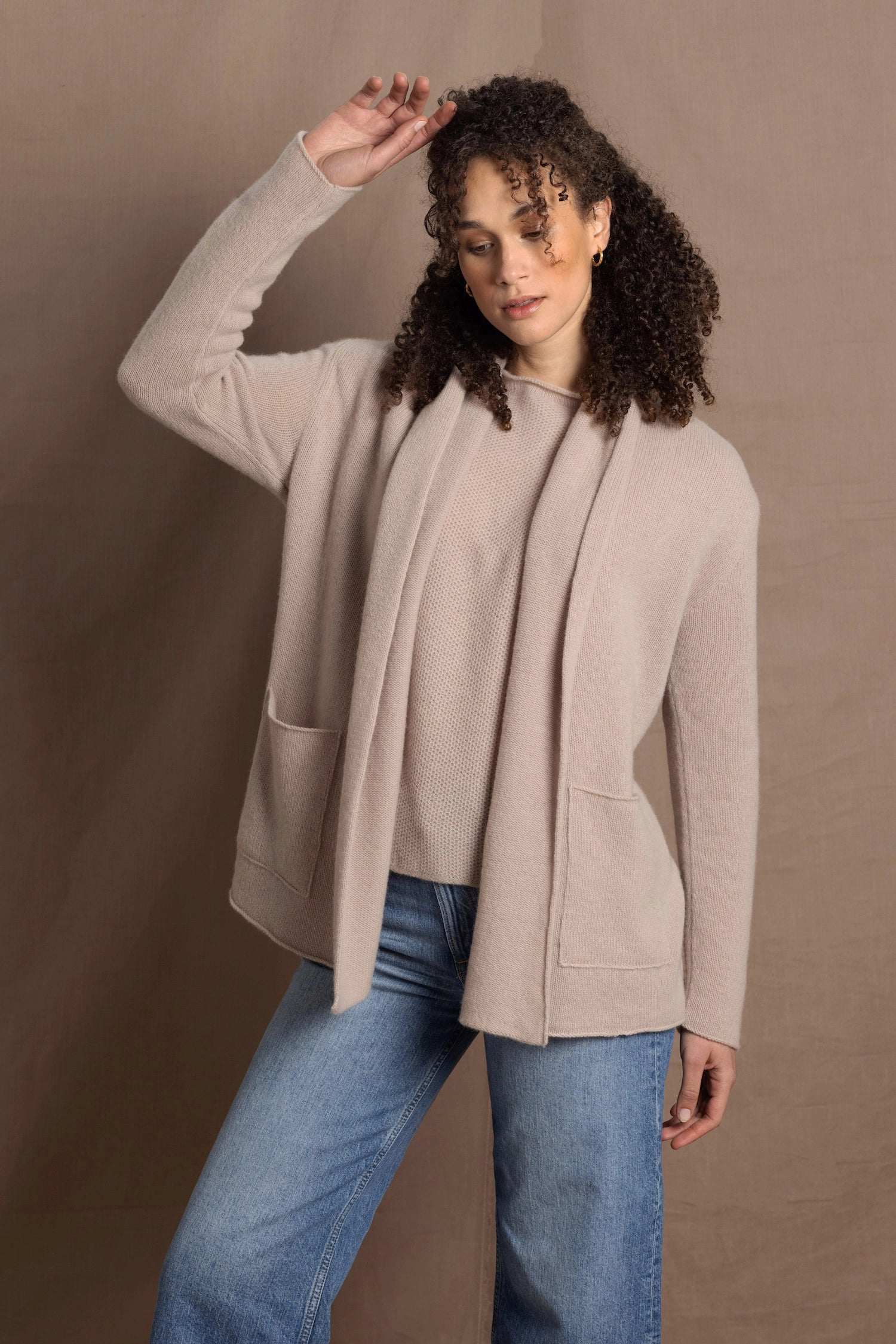 Lady wears beige coloured open cashmere cardigan over matching cashmere tee 