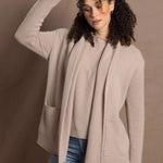 Lady wears beige coloured open cashmere cardigan over matching cashmere tee 