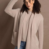 Lady wears beige coloured open cashmere cardigan over matching cashmere tee 