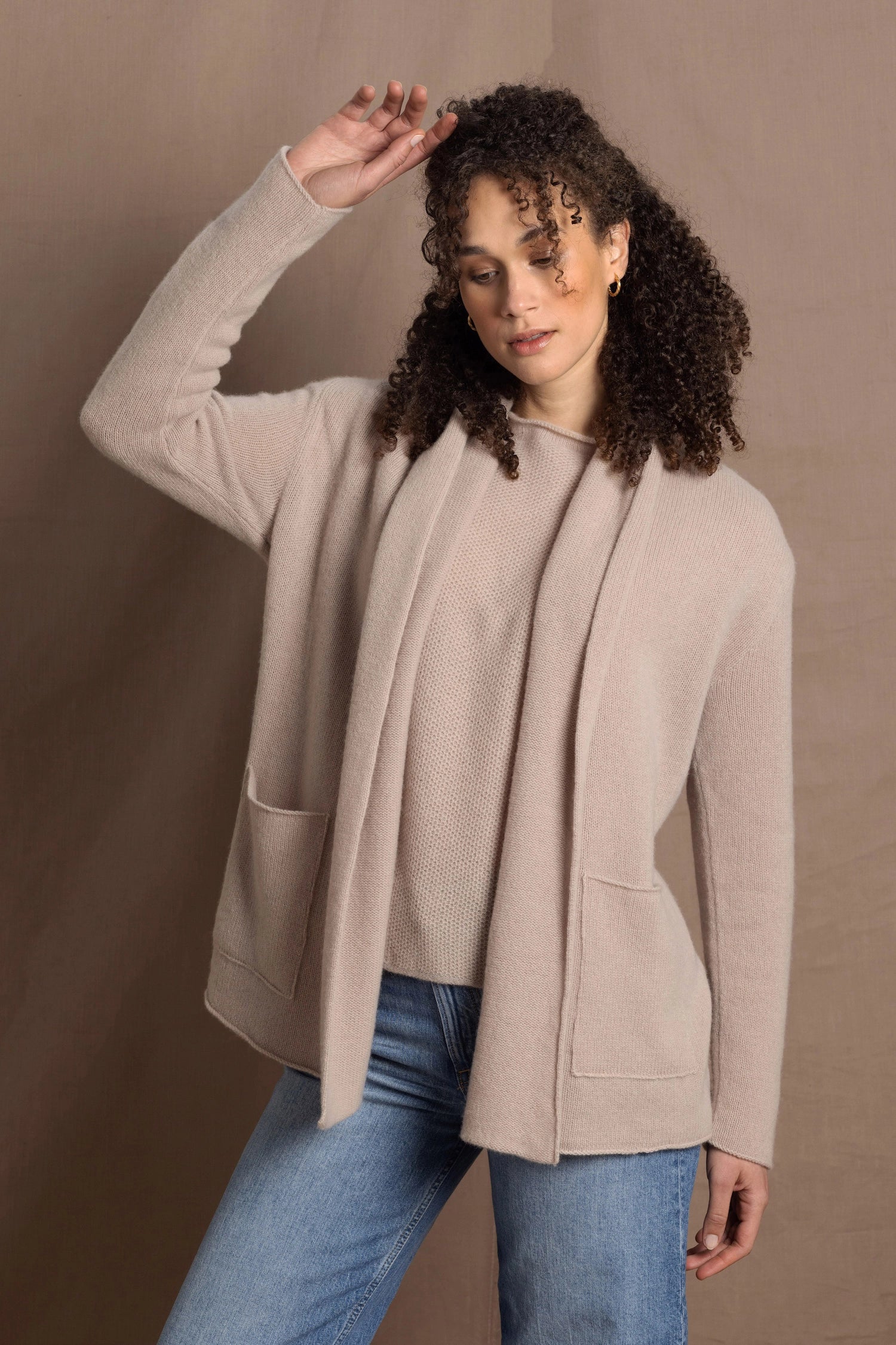 Lady wears beige coloured open cashmere cardigan over matching cashmere tee 