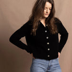 a woman wears a cashmere button down cardigan in black