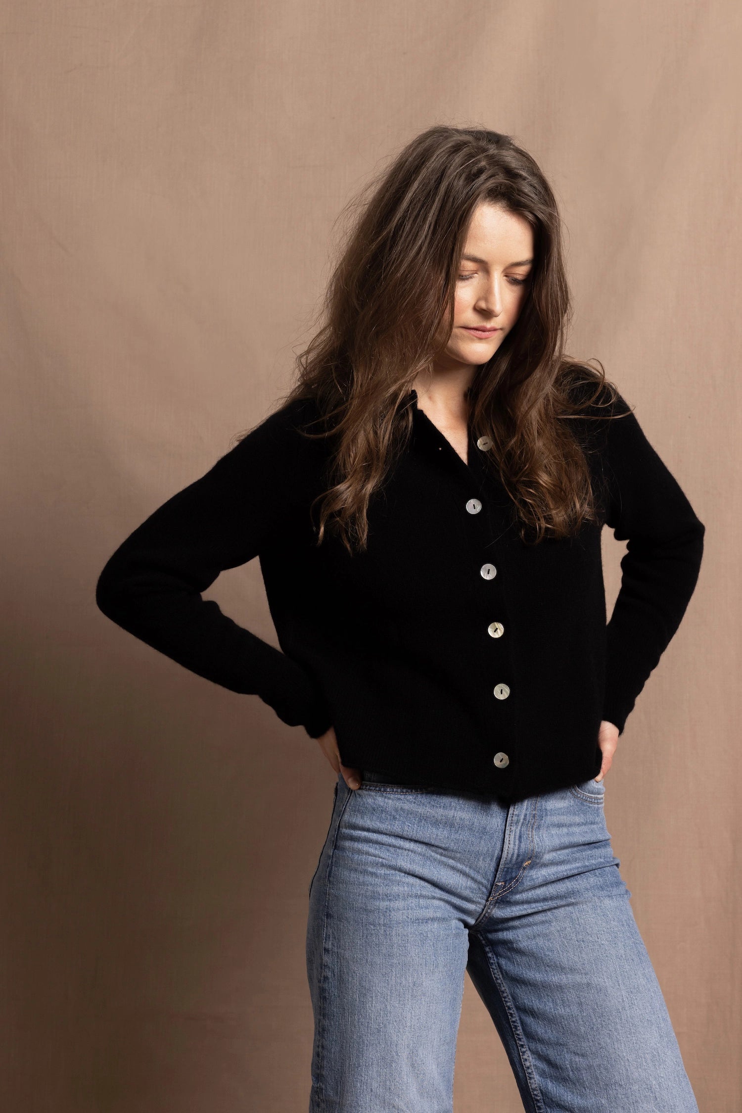 a woman wears a cashmere button down cardigan in black