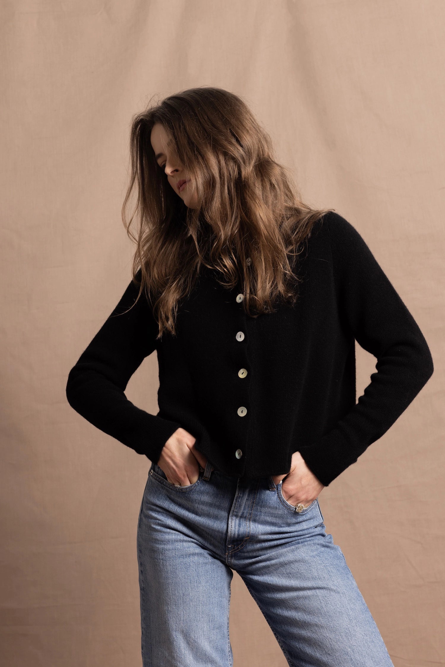 a woman wears a pure, 100% cashmere button down cardigan in black