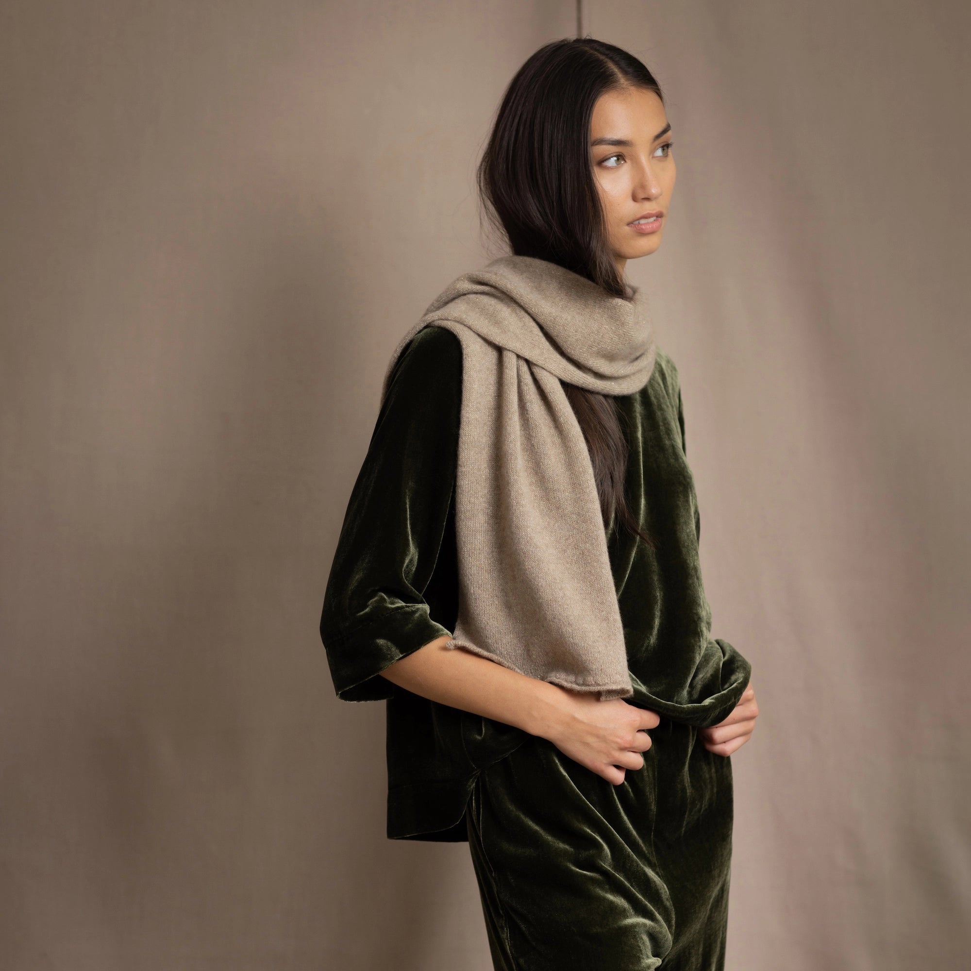 Woman wearing a beige cashmere scarf and green silk velvet outfit