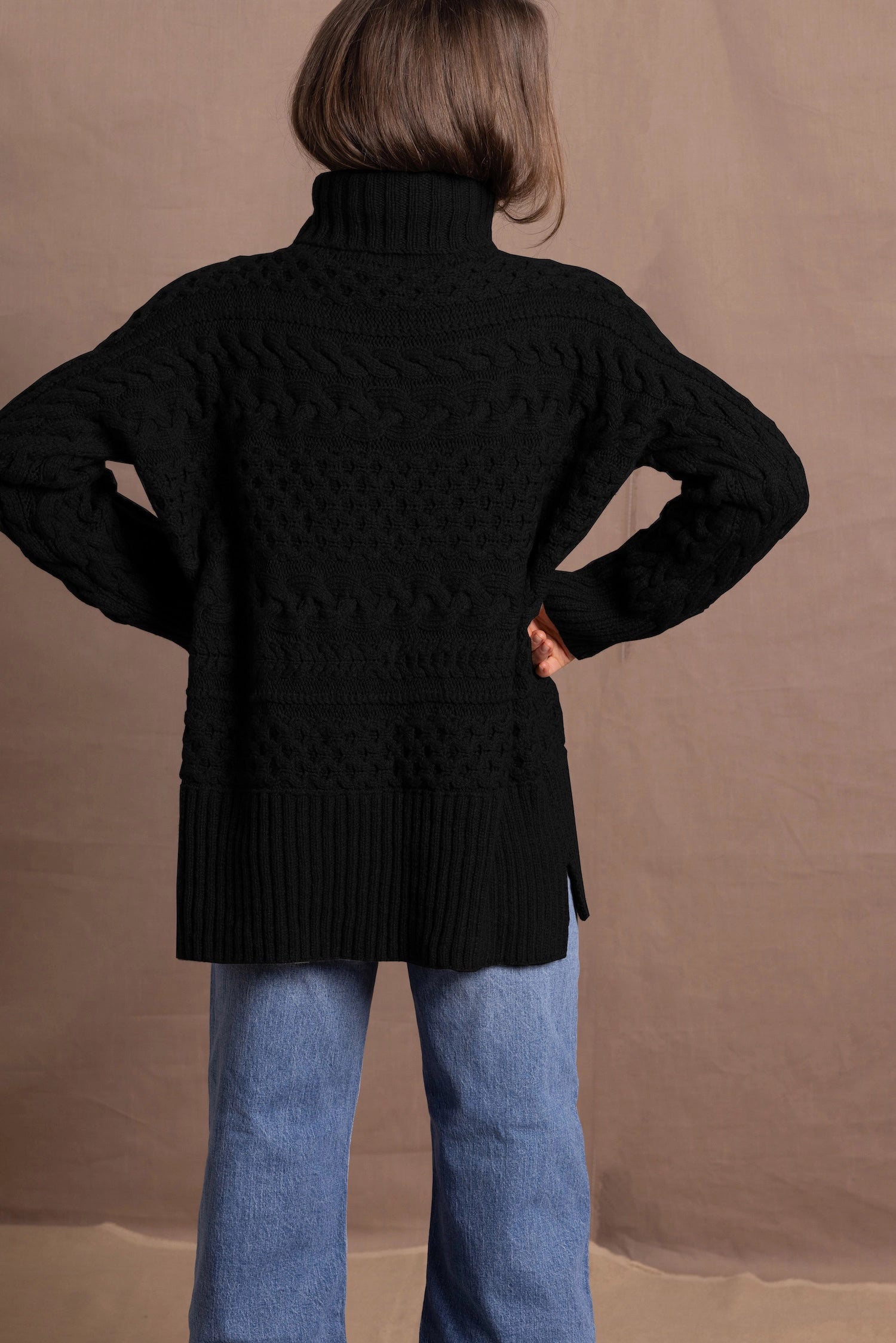 Lady wears pure cashmere aran sweater from Ireland in black