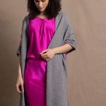 Lady wears large cashmere wrap shawl in Grey against bright pink silk clothing