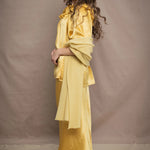 a woman wears a pure 100% cashmere wrap shawl over a silk blouse top and matching silk skirt in pale yellow from Irish brand Madigan