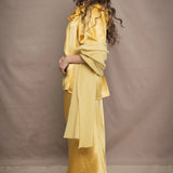 a woman wears a pure 100% cashmere wrap shawl over a silk blouse top and matching silk skirt in pale yellow from Irish brand Madigan