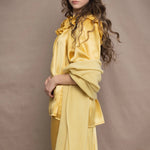a woman wears a pure 100% cashmere wrap shawl over a silk blouse top and matching silk skirt in pale yellow from Irish brand Madigan