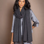 a woman wearing a black sparkly silver cashmere wrap shawl over dark grey pewter silk top and trousers by Irish luxury brand Madigan Cashmere