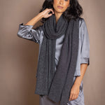 a woman wearing a black sparkly silver cashmere wrap shawl over dark grey pewter silk top and trousers by Irish luxury brand Madigan Cashmere