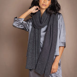 a woman wearing a black sparkly silver cashmere wrap shawl over dark grey pewter silk top and trousers by Irish luxury brand Madigan Cashmere
