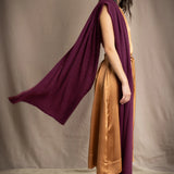 A woman models a deep plum burgundy draped cashmere wrap or shawl over her shoulder