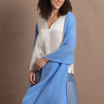 Lady wears large cashmere wrap shawl in cerulean blue