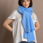 Lady wears luxurious cashmere wrap scarf in cerulean sky blue