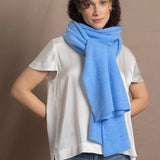 Lady wears luxurious cashmere wrap scarf in cerulean sky blue