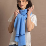 Lady wears luxurious cashmere wrap scarf in cerulean sky blue