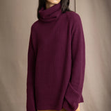 A woman wearing a fisherman cashmere knit sweater jumper  in a deep plum purple color by Irish brand Madigan Cashmere