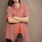 a woman wears a lightweight cashmere shawl cardigan in a dusty pink colour by Irish brand Madigan