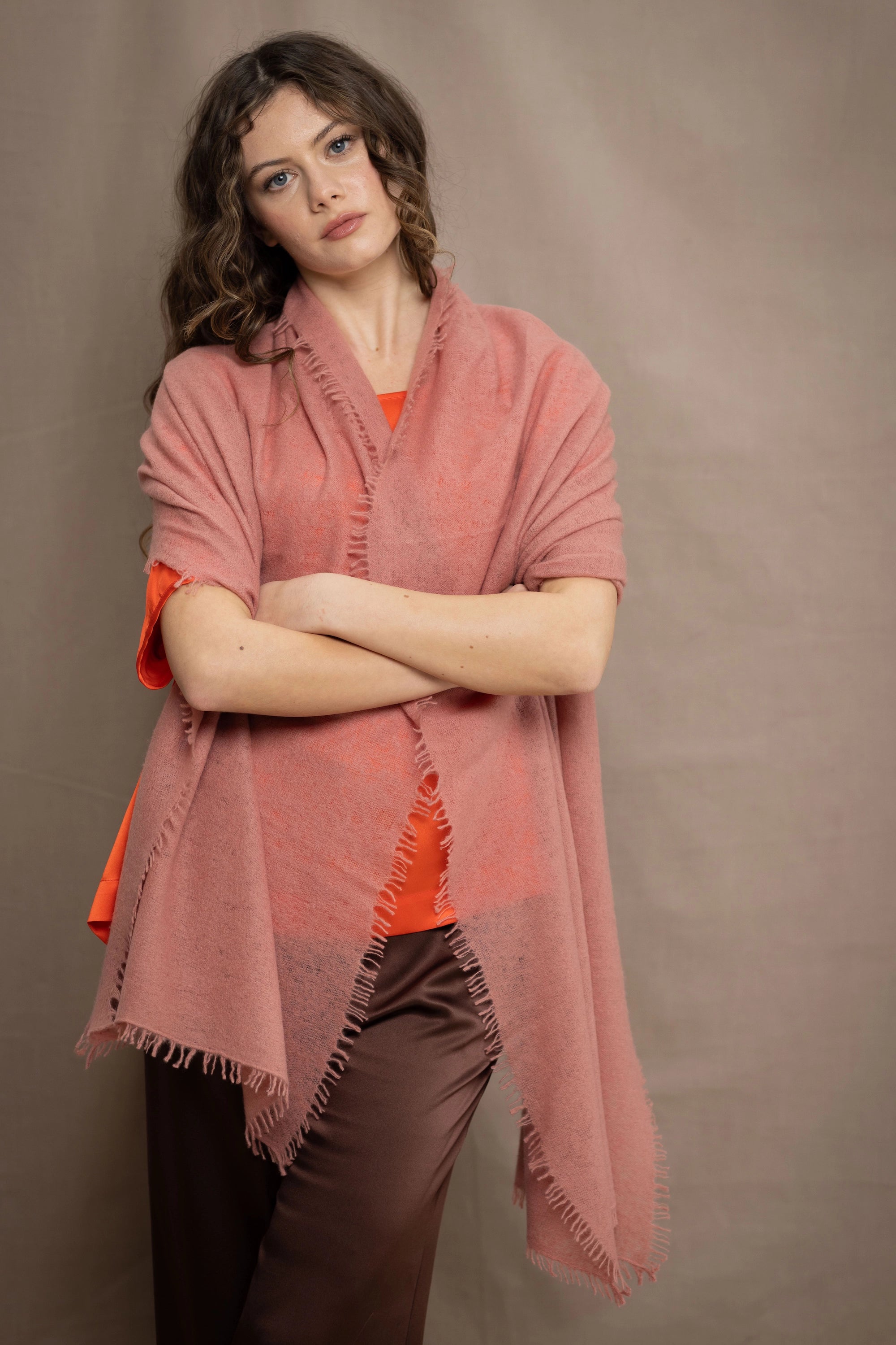 a woman wears a lightweight cashmere shawl cardigan in a dusty pink colour by Irish brand Madigan