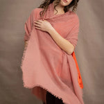a woman wears a lightweight cashmere shawl cardigan in a dusty pink colour by Irish brand Madigan