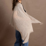 A woman wears a lightweight, fine cashmere shawl in beige